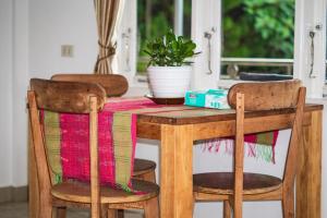 a wooden table with two chairs and a plant on it at Sophies Apartment Tuktuk in Tuktuk Siadong