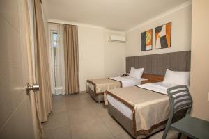 a hotel room with two beds and a table at Perle Apart Hotel in Alanya +30 photos