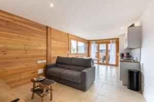 ein Wohnzimmer mit Couch und Küche in der Unterkunft Le Cocon du Lac - Vue montagnes in Les Angles