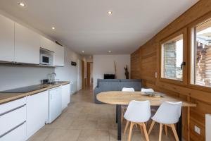 eine Küche und ein Wohnzimmer mit Tisch und Stühlen in der Unterkunft Le Cocon du Lac - Vue montagnes in Les Angles