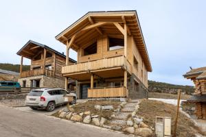 ein Haus mit einem davor geparkten Auto in der Unterkunft Le Cocon du Lac - Vue montagnes in Les Angles