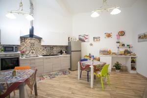 a kitchen with a table and chairs and a kitchen with a stove at B&B La Dimora di Lulù in Trapani +35 photos