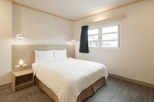 Postel nebo postele na pokoji v ubytování Kindness Hotel - Tainan Mingsheng Branch + 18 fotografií