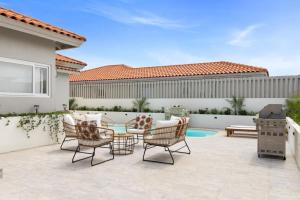 a patio with chairs and a grill in front of a house at 3BR Private Pool Retreat 4 Mins Drive by Bocobay in Palm-Eagle Beach