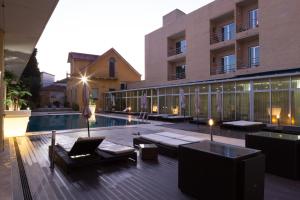 een hotelpatio met een zwembad en tafels en stoelen bij Hotel de Ilhavo Plaza & Spa in Ílhavo