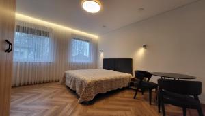 ein Schlafzimmer mit einem Bett, einem Tisch und Stühlen in der Unterkunft Svečių namai "Robeda House" in Kybartai