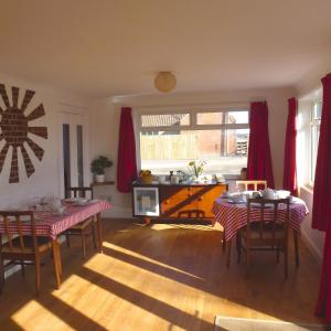 a living room with red curtains and a table and chairs at Manor Farm Stay in Sutton on Sea