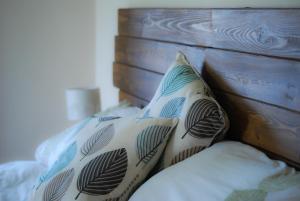 a bed with two pillows and a wooden headboard at Manor Farm Stay in Sutton on Sea