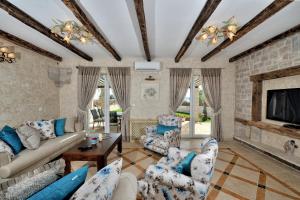 a living room with a couch and chairs and a fireplace at Vila Mila sa privatnim bazenom in Medulin