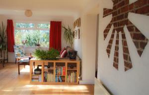 a living room with a book shelf and a window at Manor Farm Stay in Sutton on Sea