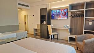 a room with two beds and a desk and a tv at Hotel President in Prato +137 photos