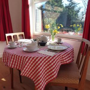 a table with a red and white striped table cloth at Manor Farm Stay in Sutton on Sea