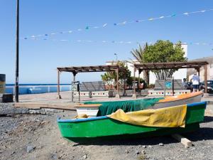 una barca verde seduta sulla riva di una spiaggia di El Pisito de Montse a Puertito de Güímar
