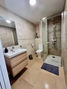 łazienka z prysznicem, umywalką i toaletą w obiekcie Apartamentos MareaBeach w mieście Torremolinos