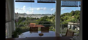 a room with a table and chairs and a large window at Apartment T3 Marina View in Le Marin