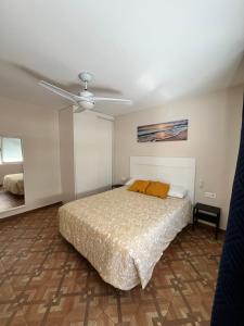 sypialnia z łóżkiem i wentylatorem sufitowym w obiekcie Apartamentos MareaBeach w mieście Torremolinos