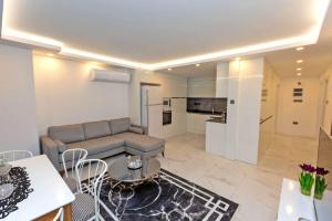 ein Wohnzimmer mit Couch und Tisch und eine Küche in der Unterkunft Cruise 2Bed Apt in Central Kyrenia in Luxury Complex by HolidayKeys in Kyrenia