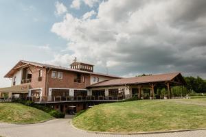a large brick building with a lawn in front of it at Hotel Golf Resort Olomouc in Dolany