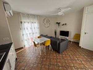 salon z kanapą, stołem i krzesłami w obiekcie Apartamentos MareaBeach w mieście Torremolinos