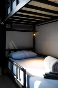 Letto a castello con cuscino blu sul letto a castello inferiore di Bad Monkey Samui Hostel a Chaweng Beach