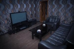 a living room with a tv and a couch and a table at Palazzo Hotel in Yerevan