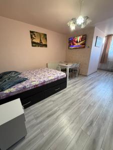 a bedroom with a bed and a table with chairs at Studio Turda in Turda