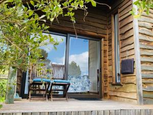 a table and chairs on the porch of a log cabin at Sunset in Harkerville +3 photos