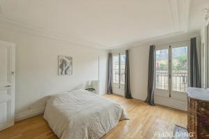 a white bedroom with a bed and a large window at Flexliving - room - Turbigo in Paris