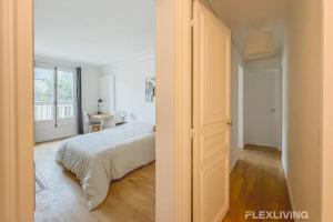 a white bedroom with a bed and a window at Flexliving - room - Turbigo in Paris