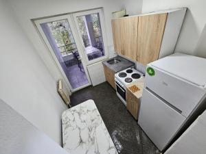 eine kleine Küche mit Herd und Kühlschrank in der Unterkunft Avtokomanda in Skopje