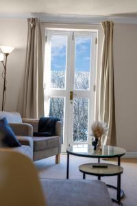 Una sala de estar con un sofá y una mesa y una ventana. en 1 Double Room in Shared apartment in Central Edinburgh with free parking, en Edimburgo