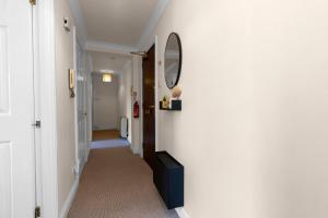 un pasillo con una pared blanca y un espejo en la pared en 1 Double Room in Shared apartment in Central Edinburgh with free parking, en Edimburgo