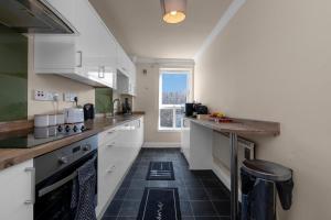 cocina con armarios blancos y suelo de baldosa negra en 1 Double Room in Shared apartment in Central Edinburgh with free parking, en Edimburgo 19 fotos más