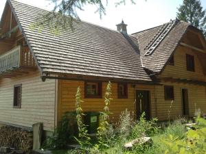 a wooden house with a metal roof at Bungalov Tina in Žiar