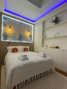 una camera da letto con un letto bianco con una grande finestra di Appartement PARIS avec Parking a Vanves