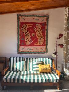 a rug hanging on a wall with a couch at Solanas, Casa Cacteae, villa 5 min to the beach in Solanas