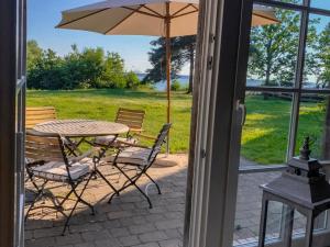 a patio with a table and chairs and an umbrella at Fischerhäuser in Quilitz in Quilitz