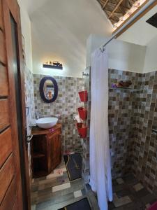 a bathroom with a shower with a sink and a mirror at Karibokite in Antsiranana +43 photos