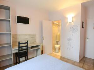 a bedroom with a bed and a desk and a chair at Alliance Hôtel Paris in Paris