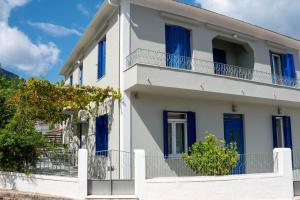 a white house with blue shutters at Captains' house in Vathi, Ithaka