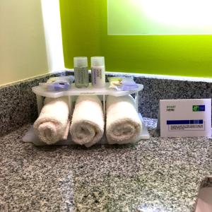 a shelf with rolls of towels and candles on a counter at Holiday Inn Express & Suites Mexicali, an IHG Hotel in Mexicali