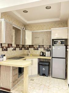 a kitchen with white cabinets and a white refrigerator at Beautiful apartment overlooking King Road in Jeddah