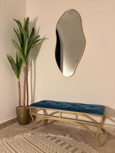 a mirror on a wall next to a bench with a mirror at Beautiful apartment overlooking King Road in Jeddah
