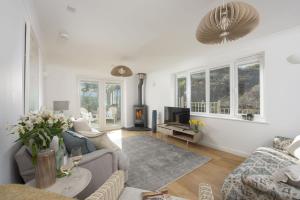 a living room with a couch and a tv at Poldreth - situated above the golden sand and rolling waves of Porthtowan Beach in Porthtowan