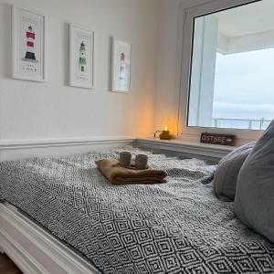 a bed with two cups and a towel on it at An de Waterkant in Schausende