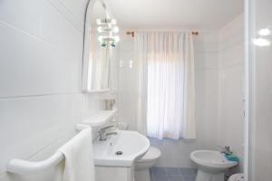 a white bathroom with a sink and a toilet at Casetta a due passi dal mare in Siniscola +18 photos