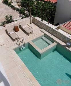 una piscina con due sedie a sdraio e una piscina di Gemini Resort a Kalamaki