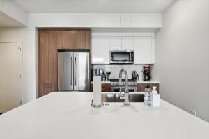 a white kitchen with a sink and a refrigerator at 2880 Japandi Minimalism at Espadin in Denver