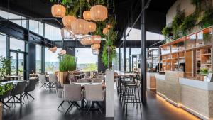 ein Restaurant mit Tischen, Stühlen und Kronleuchtern in der Unterkunft Molecaten Park Waterdunen in Breskens