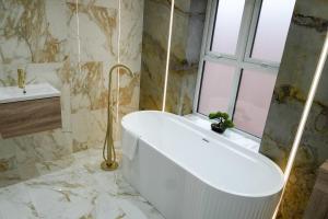 a white bath tub in a bathroom with a window at Santi House in Boston